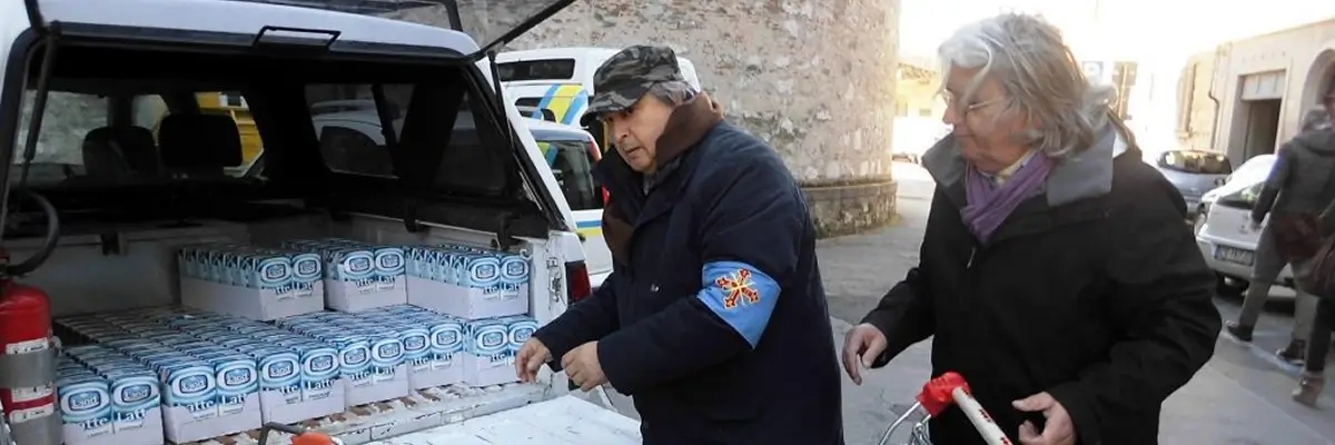 Volontari dell'Ordine Costantiniano di San Giorgio distribuiscono confezioni di latte