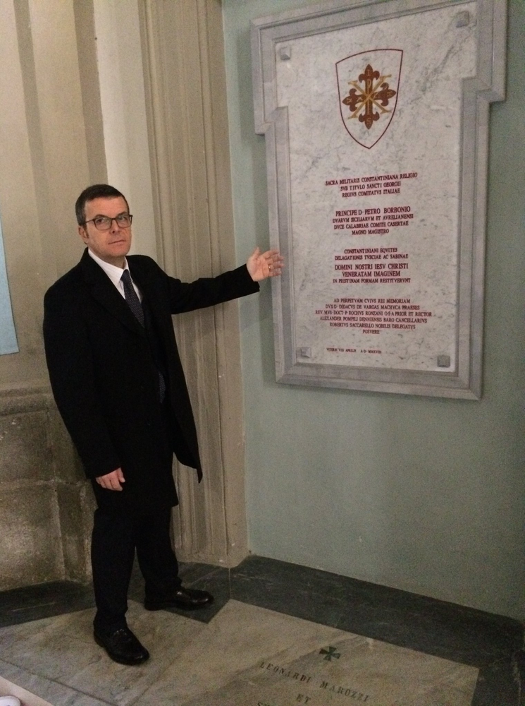 Il Vice Delegato e Tesoriere della Delegazione della Tuscia e Sabina, il Nob. Dott. Sandro Calista, Cavaliere Jure Sanguinis con Placca d'Oro indica la targa in ricordo della cerimonia dell’8 aprile 2018.